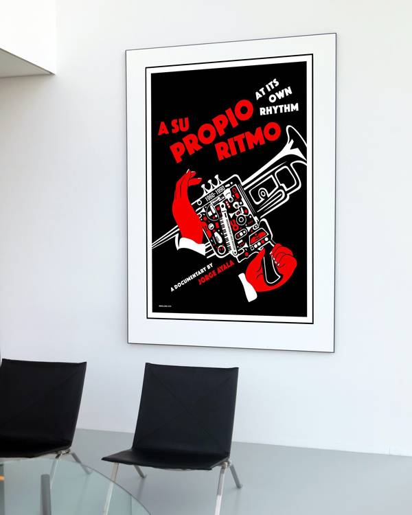 Modern interior with framed Cuban silkscreen poster for the documentary ‘A Su Propio Ritmo’ by Jorge Ayala. Designed in bold black, red, and white, the poster features a stylized trumpet with red-gloved hands and tiny musical instruments.